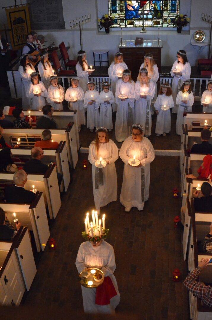 A group of people in white robes holding candles.